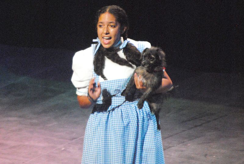 A woman dressed as Dorothy performing with a dog