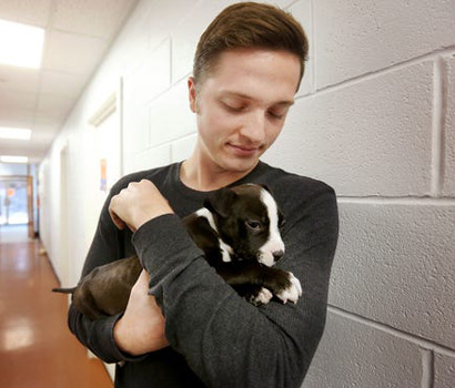 Garrett Parson holding a puppy named Duke.