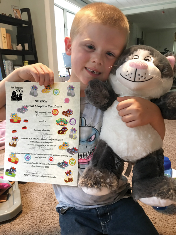 a boy holds up a certificate and a stuffed cat