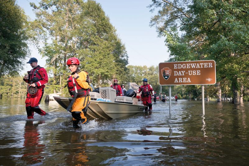 People lead a boat through a heavily flooded area