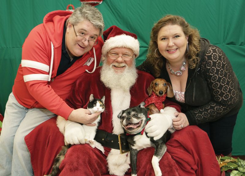 Santa poses with a couple, two dogs and a cat