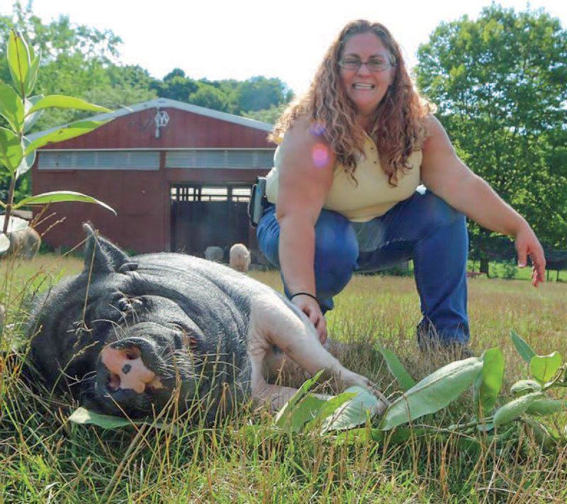 Lollypop Farm farm and safety manager Joanna Dychton poses with Maggie May. The 13-year-old potbellied pig was surrendered to the shelter because her former owners lived in an area that wasn’t zoned for pet pigs
