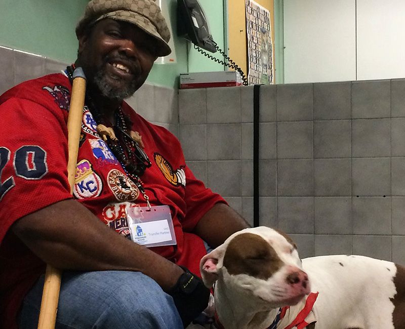 a smiling man reunited with his dog