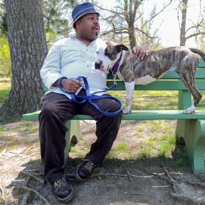 A man sitting on a bench with a dog