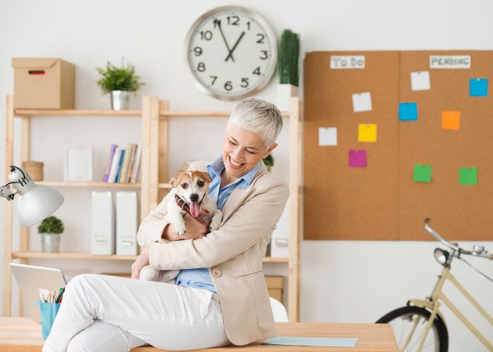 a woman holding a dog in an office setting